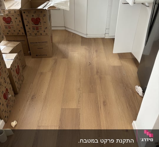 רצפת פרקט עץ בהירה במטבח עם קופסאות קרטון